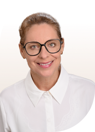 Frau mit zurückgebundenem Haar trägt weiße Bluse mit spitzem Kragen.