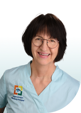 Person mit kurzem braunem Haar trägt hellblaues medizinisches Oberteil mit Logo und Schriftzug 'Augenzentrum Offenburg Kinzugtal'